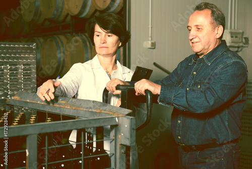 Expert and wine maker inspect containers photo