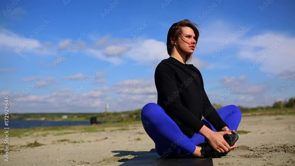 Young woman doing yoga exercise on summer sand beach at sunset, workout. Young woman doing yoga exercise on summer sand beach at sunset, workout.