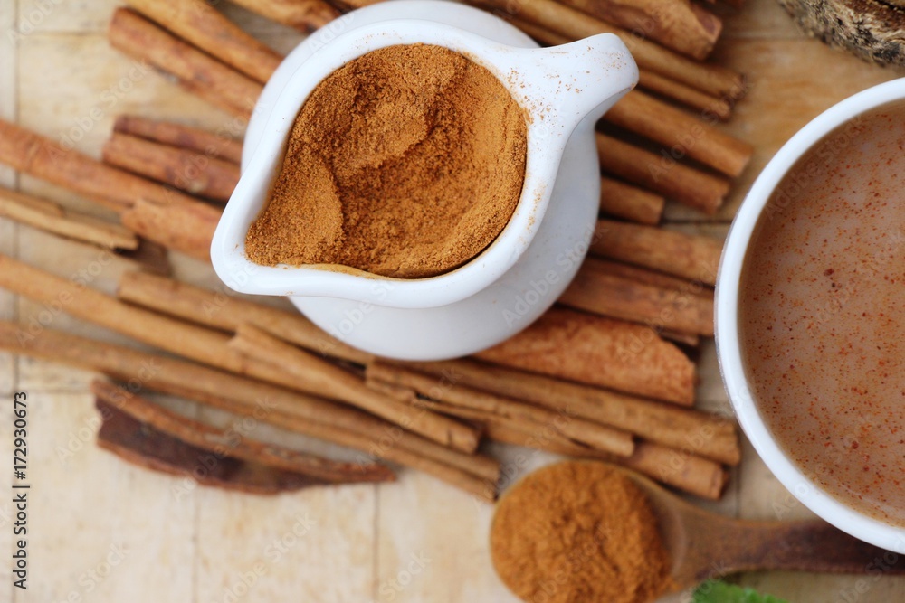 Cinnamon powder and sticks on wood background Cinnamon powder and sticks on wood background