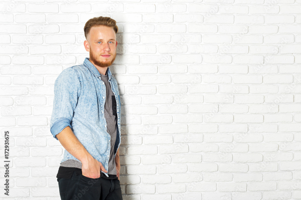 Young Sexy Man Against a White Brick Wall Young Sexy Man Against a White Brick Wall