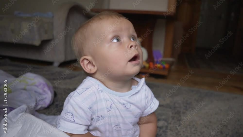 the little child crawls in the diaper in a white T-shirt the little child crawls in the diaper in a white T-shirt