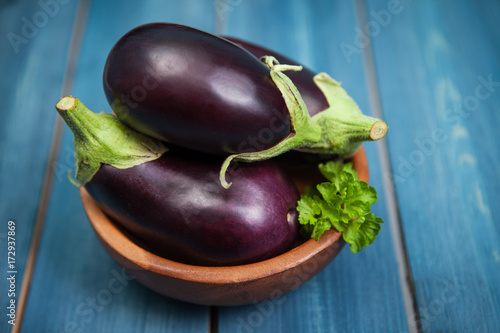 Fresh healthy eggplants on dark wooden background.