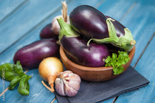 Fresh healthy eggplants on dark wooden background.