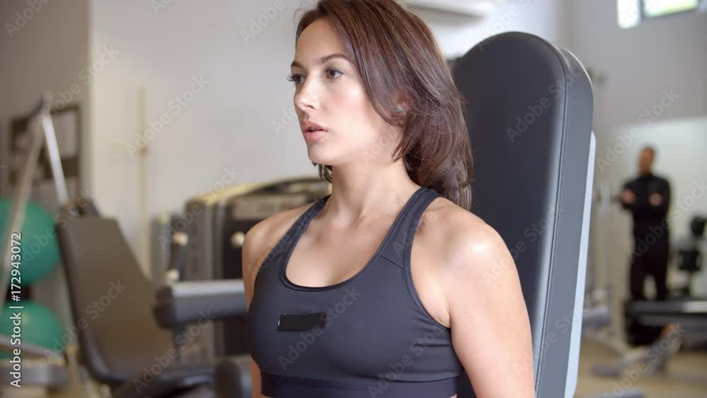 Woman working out with dumbbells at gym, side view close up Woman working out with dumbbells at gym, side view close up