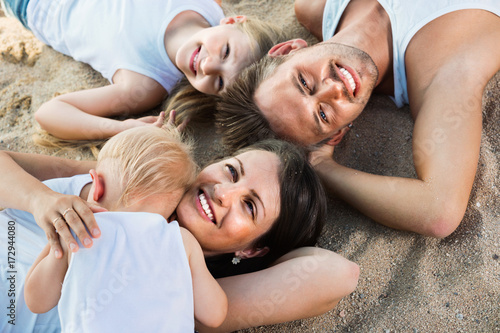 Top view on parents with kids relaxing on beach