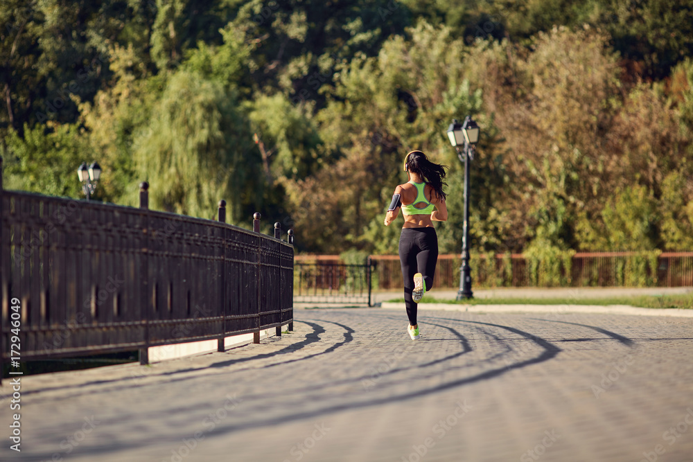 A girl jogging in the park. Healthy lifestyle.