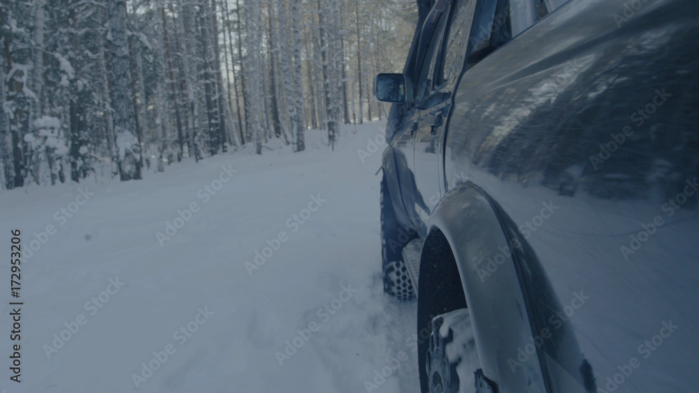 Jeep rides on the snow in the forest closeup.