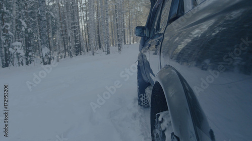Jeep rides on the snow in the forest closeup. © Media Whale Stock