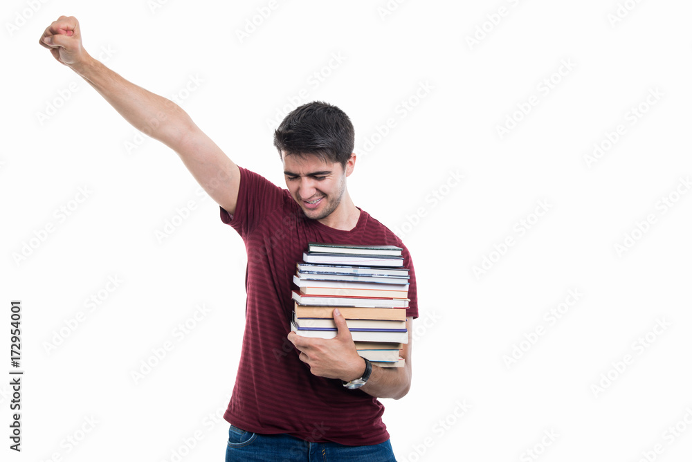 Student holding pile of books showing winner gesture Student holding pile of books showing winner gesture