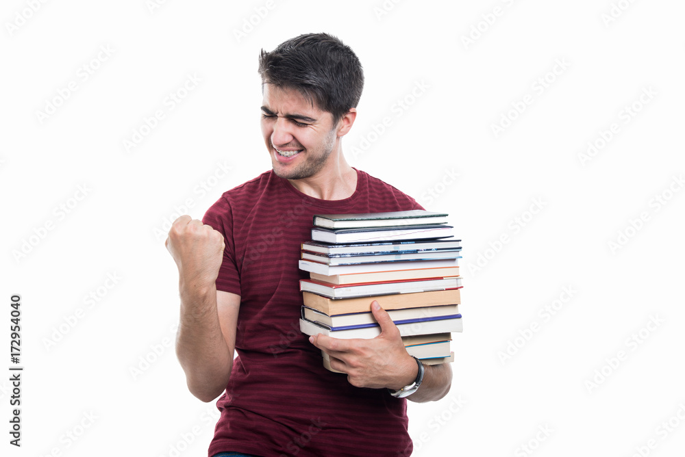 Student holding pile of books showing winner gesture Student holding pile of books showing winner gesture