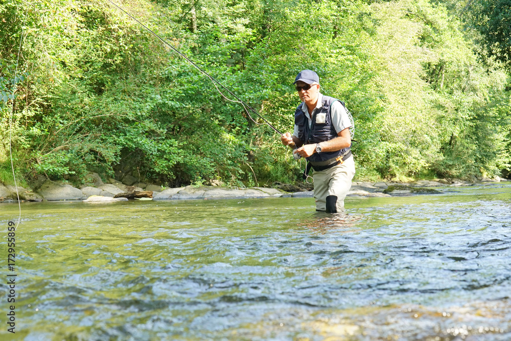 Fly fisherman fishing in French river Fly fisherman fishing in French river