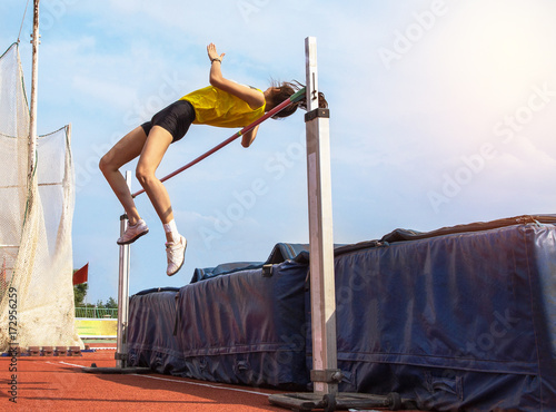 female athlete in action high jump over bar in track and field