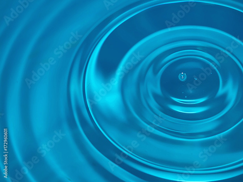 Cerchi nell'acqua azzurra decentrati generati da piccole gocce d'acqua per sfondo astratto photo