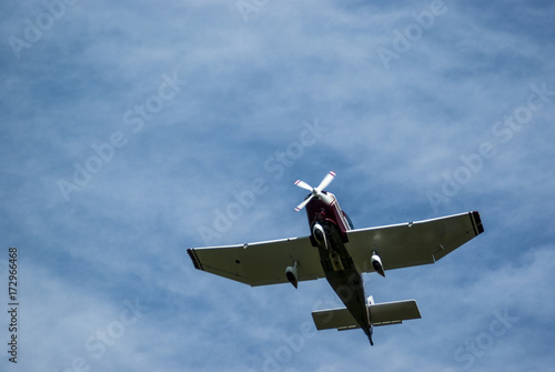 Blick von unten auf eine fliegende Jodel mit drehenden Propeller bei Sonnenschein und Schleierwolken, View from below on a flying jodel with rotating propellers at sunshine and veil clouds photo