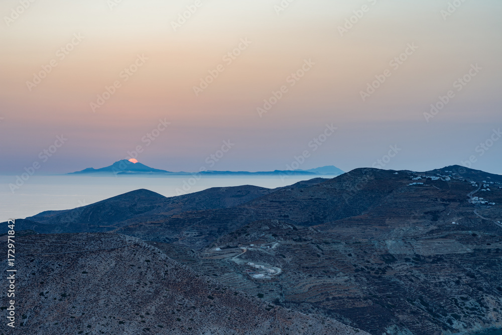 Sole che tramonta dietro l'isola di Milos visto da Folegandros, arcipelago delle isole Cicladi GR