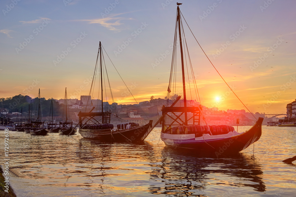 Porto old town skyline on the Douro River with rabelo boats at sunset