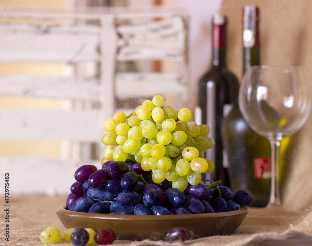 Blue and green grapes on a clay brown dish