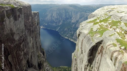 Norwegian fjord panoramic view over the mountain. Backward motion of the camera. Watch through the rocks. Wonderful Norwegian nature. Great centuries-old rocks, covered with greenery. Clear blue river