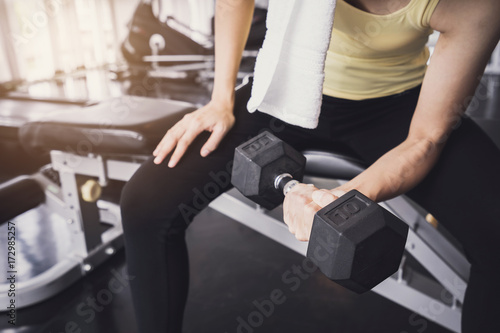 Young asian women lifting dumbbell in sport gym
