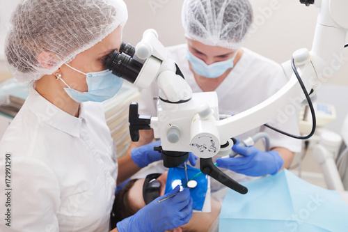 professional dentist examination patient with microscope at the office