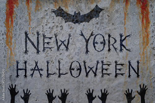 Inscription NEW YORK HALLOWEEN on bloody wall with bat and corpse hand silhouettes. Zombie poster concept and greeting card template.