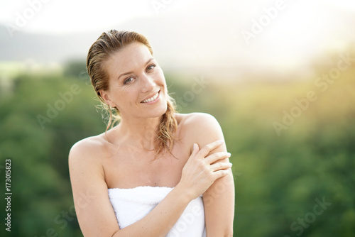 Beautiful woman standing outside with towel around wraist