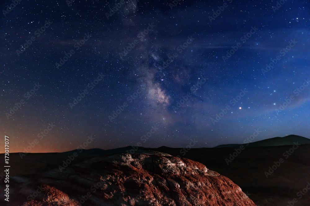 Milky way on starry sky over red mountains