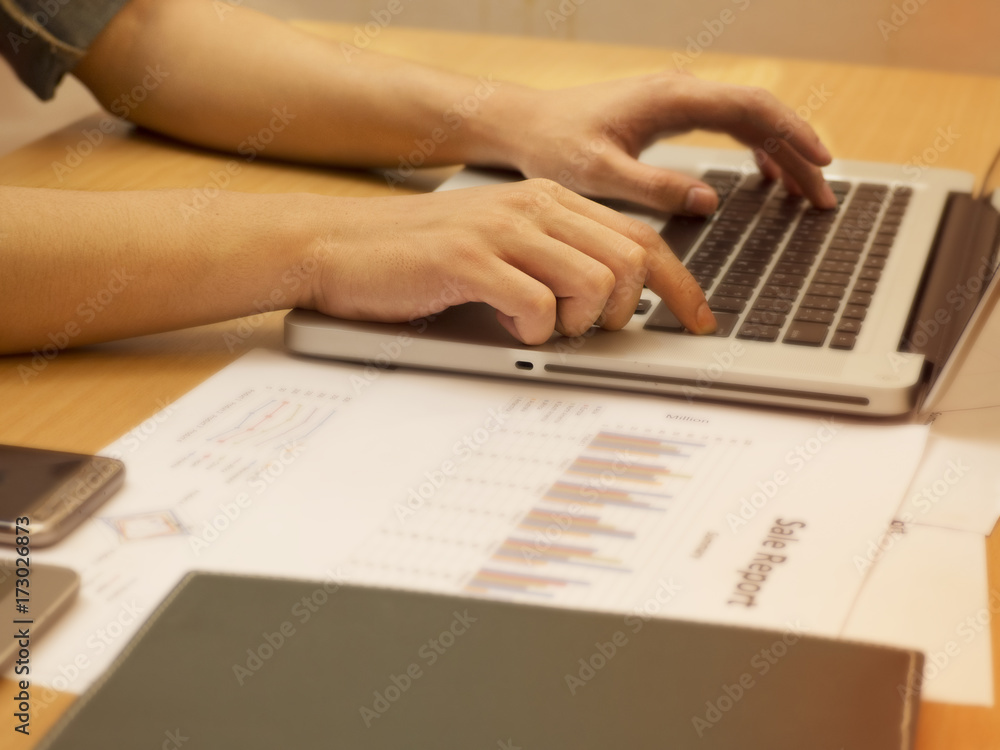 The human hand is pressing on laptop keyboard in vintage tone,blurry light office background. The human hand is pressing on laptop keyboard in vintage tone,blurry light office background.
