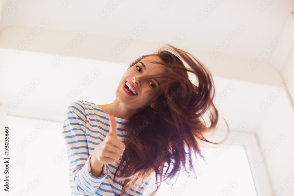 Portrait of young cheerful beautiful woman who showing thumb up in the room Portrait of young cheerful beautiful woman who showing thumb up in the room