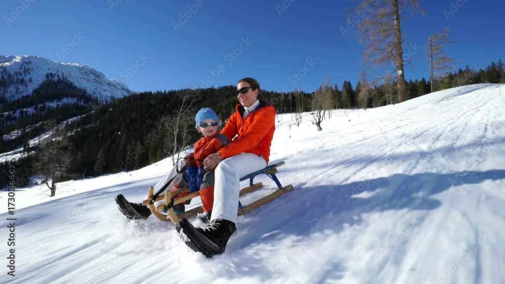 happy mom with baby son sledging down snow sled run on sunny winter day
happy mom with baby son sledging down snow sled run on sunny winter day