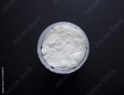 French fromage blanc (fresh cheese) in small portion sized cheese basket isolated on black background