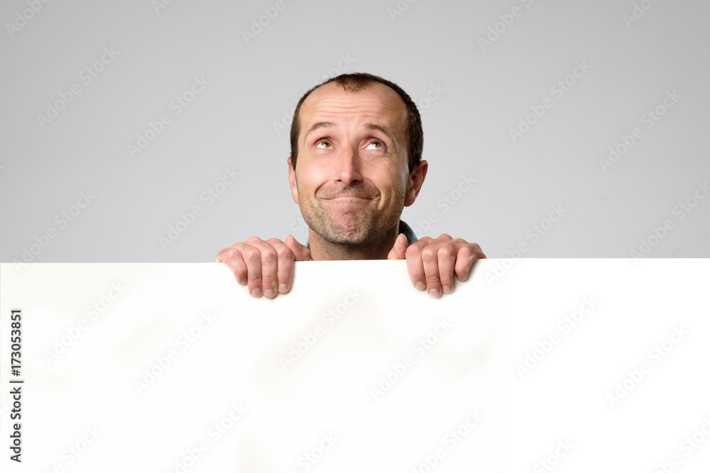 Hispanic man holds the blank sign in a studio white background. Hispanic man holds the blank sign in a studio white background.