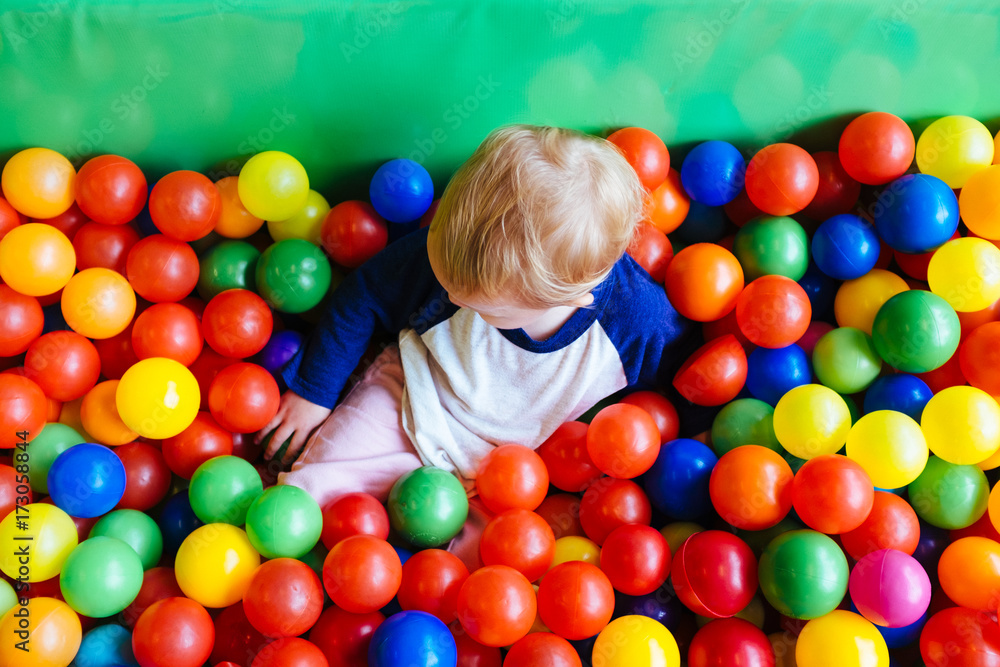 Arial view of toddler girl in colerful, fun ball pit Arial view of toddler girl in colerful, fun ball pit