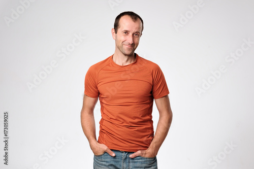 Smiling mature caucasian man standing with arms in pockets