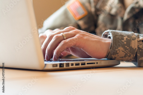Closeup of hands of a soldier using a laptop