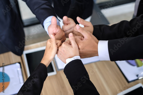 Asian business people joining hands with colleagues together at meeting time for develop job to success, business colleagues teamwork concept