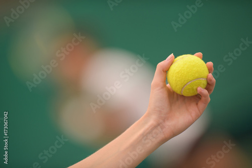 tennis ball and hand on hard court © auremar