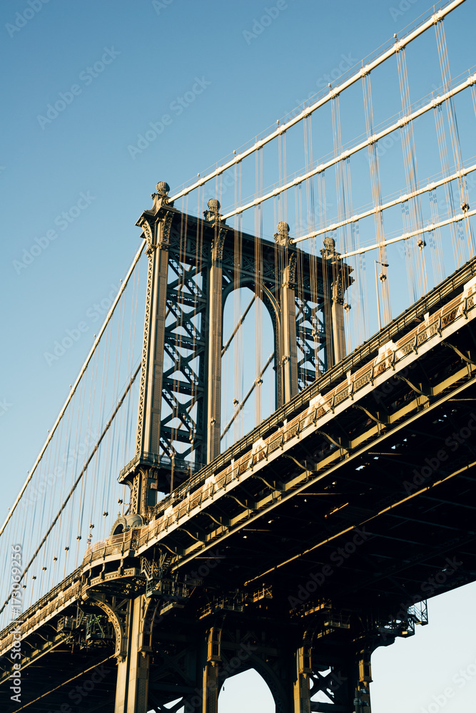 Low angle view of Manhattan Bridge against blue sky Low angle view of Manhattan Bridge against blue sky