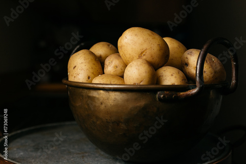 Brass bowl with yellow potatoes