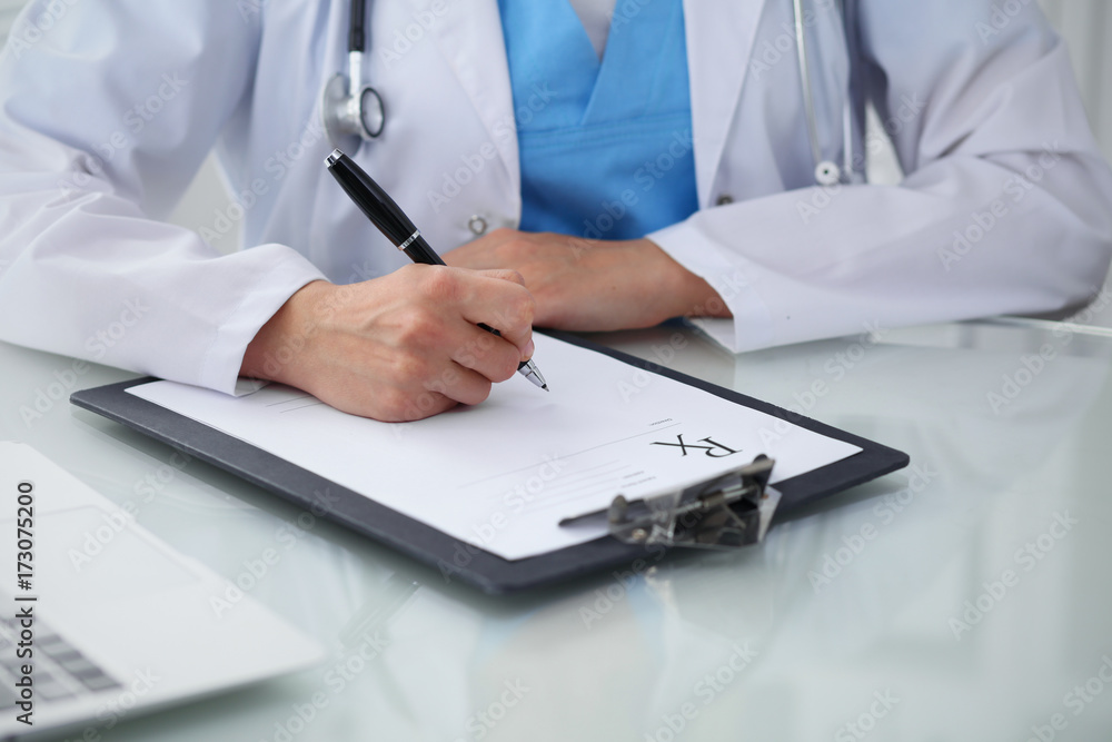 Doctor woman filling up prescription, close-up of hands. Physician at work. Medicine and healthcare concept Doctor woman filling up prescription, close-up of hands. Physician at work. Medicine and healthcare concept