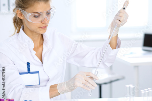 Female scientific researcher in laboratory studying substances. Medicine and science concept