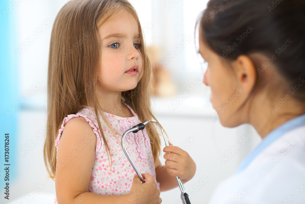 Happy little girl at health exam at doctor office. Medicine and health care concept Happy little girl at health exam at doctor office. Medicine and health care concept