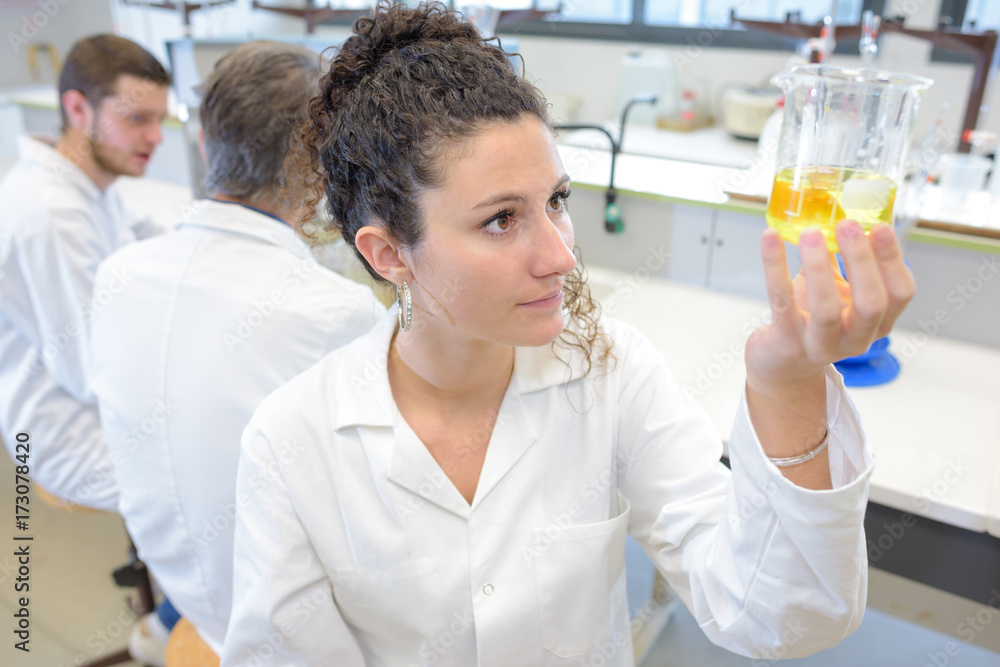 concentrated young female scientist holding test tube concentrated young female scientist holding test tube