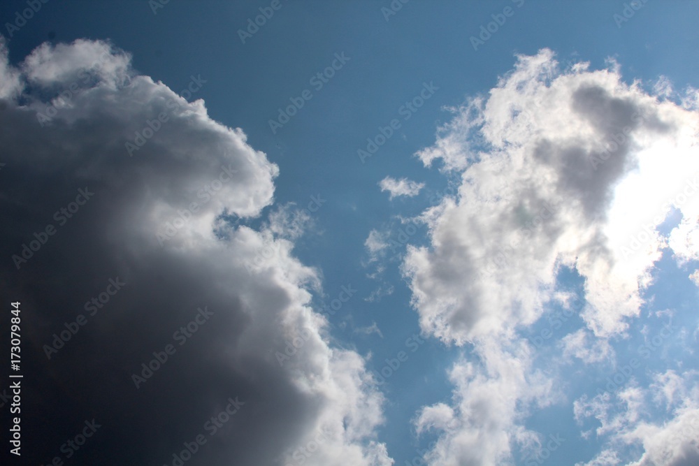 The mix of dark and white puffy clouds in the blue sky.