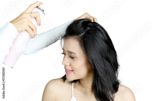 Hairdresser using a hairspray for her model