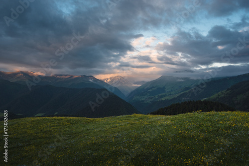 Landscape of Georgian mountains at sunrise. Beautiful clouds over mountains.