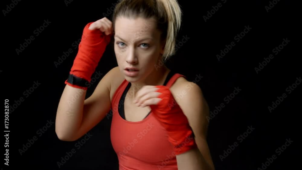Blonde female boxer shadow boxing to camera, close-up Blonde female boxer shadow boxing to camera, close-up
