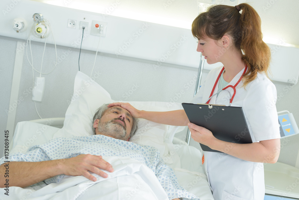 touching the patient's forehead touching the patient's forehead