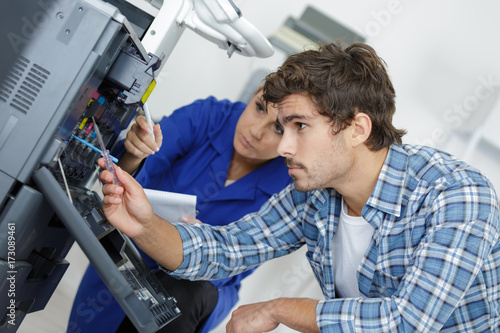 two young technicians repairing printer