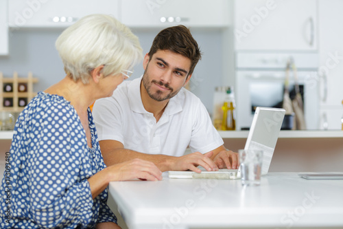 grandson showing senior woman online computer use © auremar